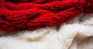 Rote Strick-Wolldecke und beige Lammfellimitat Decke